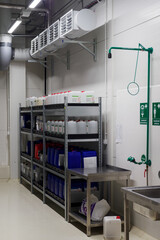 Shelf with chemical barrels, suction and first aid shower.
