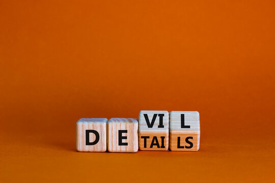 Devil in the details symbol. Turned cubes and changed the word 'details' to 'devil'. Beautiful orange background. Business and devil in the details concept. Copy space.