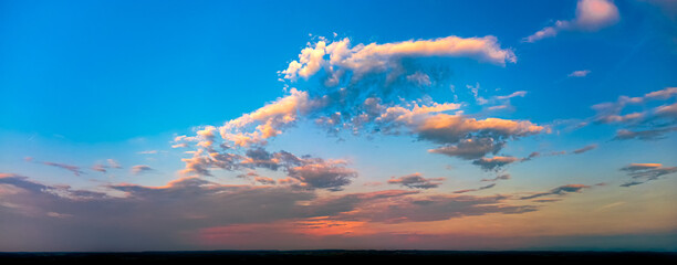 Fototapeta na wymiar Panorama of blue sky and orange clouds before sunset