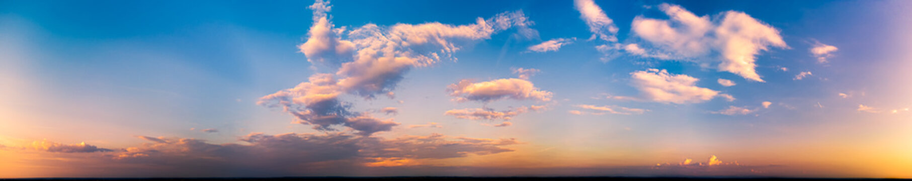 Sunset panorama of blue sky and orange clouds.
