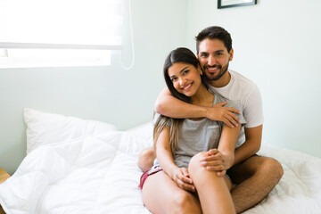 Hispanic couple in bed getting up early