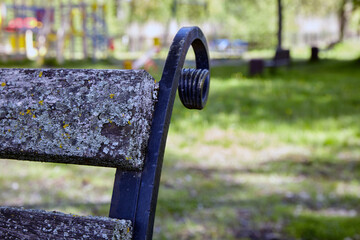 The park bench is covered with lichen and moss