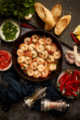 Fried baby Shrimps served on iron pan and fresh herbs and ingredients. Top view, flat lay
