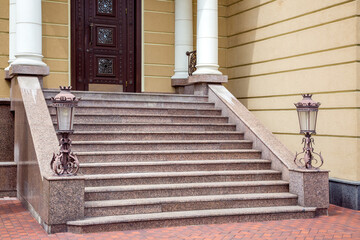 granite staircase with iron forged retro street lighting lanterns on the threshold with columns at...