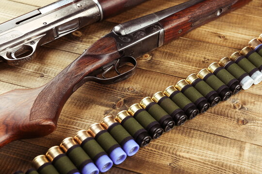 vintage hunting rifles and bandolier on a wooden background, top view.