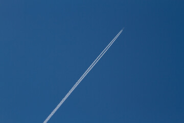 Air Plane Contrails in a clear blue sky Travelling some where.