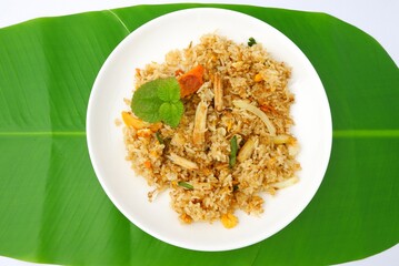Delicious crab fried rice on a white plate on a green leaf background.Thai food.