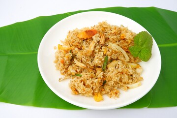 Delicious crab fried rice on a white plate on a green leaf background.Thai food.