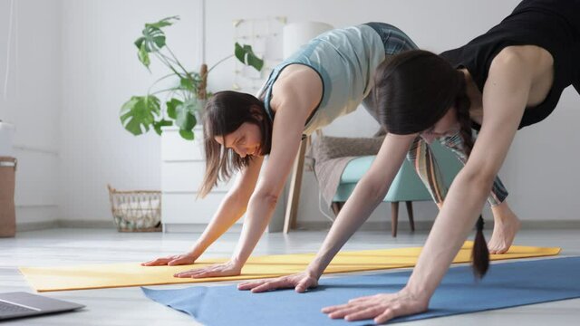 Yoga home Active lifestyle during lockdown slim women friends do yoga Spbi