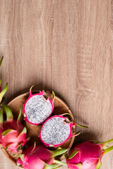 Fototapeta na wymiar Dragon fruit or pitaya on wooden background with copy space, Tropical fruit, Table top view