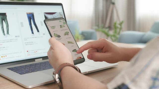 Close Up Hand Man Using Smartphone And Laptop Computer Order Vegetables And Clothes Online, Online Shopping
