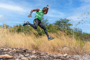 female trail runner jumping on running on trail on mountain in summer