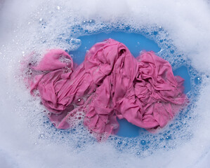 Wet color clothes with white foam Soak before washing,top view