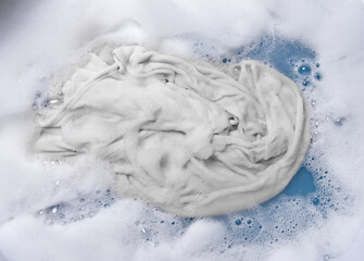 Wet whites clothes with white foam Soak before washing,top view