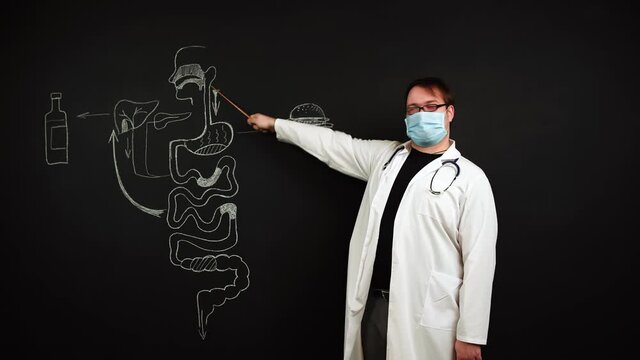 Instructions for proper nutrition are told by a scientist doctor in a white lab coat and a medical mask. Sketch illustration with chalk of the human digestive system with fast food and alcohol.