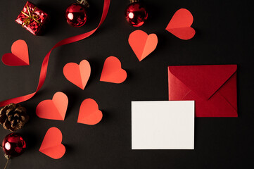 White paper and red heart paper pasted on a black background.