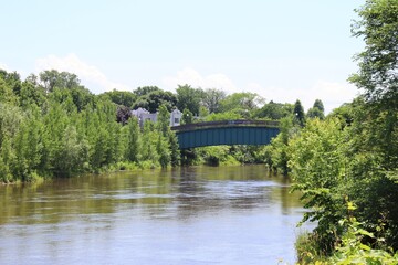 Fototapeta na wymiar Vue sur la rivière St-Charles dans la ville de Québec. Vue sur un pont et une rivière en été. Photographie zen avec eau et arbres.