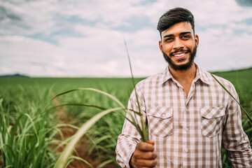 Young Latin farmer working on sugarcane plantation. Brazilian farmer.