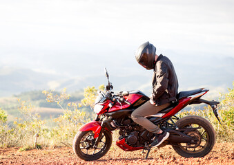 Fototapeta na wymiar Young man riding his motorbike and enjoying the road trip. travel concept