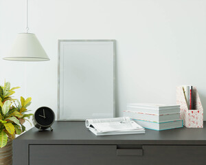 The study room is decorated with a table, picture frames, lamps and small potted plants.