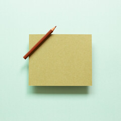 Khaki memo pad with colored pencil on blue background. top view, copy space