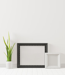 A photo frame placed on the floor with a flower pot.