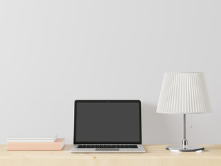 A working room with a laptop with a lamp placed on the table.