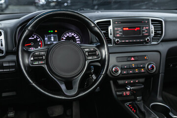 car Interior - steering wheel, shift lever and dashboard, climate control, speedometer, display.