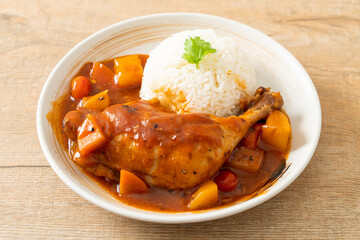 chicken stew with tomatoes, onions, carrot and potatoes on plate with rice