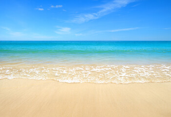 Fototapeta na wymiar Summer sand beach with ocean waves and blue sky background.