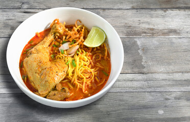 chicken khao soi, thai northern noodle on wooden board.