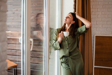 Girl drinking tea and enjoying sunlight at home