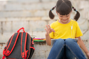 Asian little girl taking class on line and happy