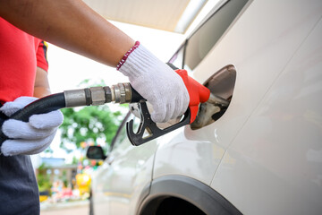 Fototapeta premium Close-up of a gas station worker working with a gasoline injector pump. to refuel Petrol pump - refueling Car refueling station.