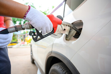 Close-up of a gas station worker working with a gasoline injector pump. to refuel Petrol pump - refueling Car refueling station.