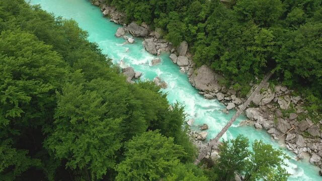 Aerial &ndash; Soča river rapids underneath a small and wooden hanging bridge