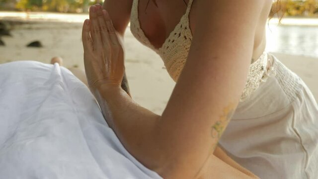 Lomi Lomi Back Massage At Echo Beach. Masseuse Applying Pressure With Forearm And Hand On Back Of A Woman. close up