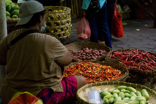 Denpasar, Bali, Indonesia (19 June 2021): The traditional market of Denpasar city, called the "Kumbasari" market. A woman is sitting selling chilies and spices