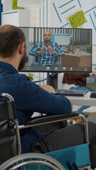 Paralized invalid immobilized freelancer talking on videocall with remote colleague with disabilities discussing online sitting in front of pc in wheelchair. start-up office during virtual meeting