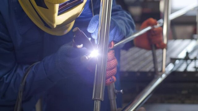 Man wearing mask welding in a workshop. Metal workers use manual labor. Skilled welder. Welder is welding the stainless steel pipes in the factory. welder Industrial part in factory.