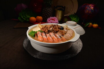 braised premium seafood mixed in clay pot Peng cai with big prawn, herbal, abalone mushroom, vegetables for banquet menu