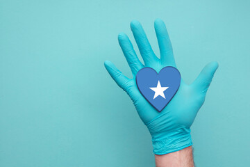Somalia medical health heart. Nurse hand holding country heart flag