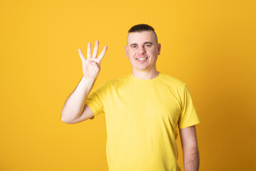 Young handsome man smiling showing four  finger of hands. Number four.