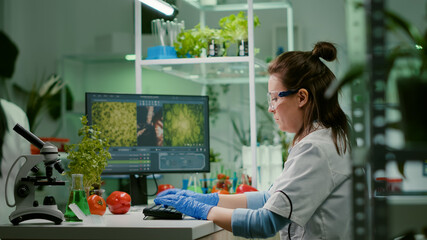 Scientist woman researcher typing biochemistry expertise on computer for microbiology experiment. Medical team working in pharmaceutical laboratory analyzing genetic mutation