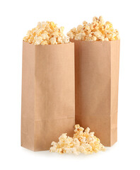 Paper bags with tasty popcorn on white background