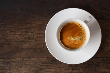 dark rost espresso coffee on white cup on old wooden table background with copy space.