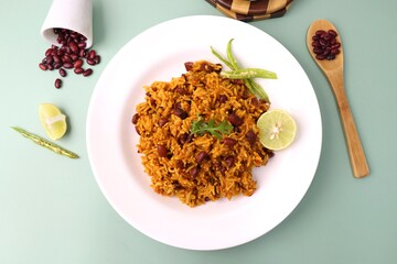 Indian cuisine - Kidney Beans Biryani, Rajma Pulao. Garnished with chopped coriander, and lemon wedges. Rajma biryani served with dahi. Along with copy space. Rajma Chawal flatlay.