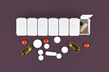 Pill box with many different medical pills and casuals