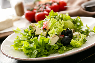 Plate with fresh Greek salad on dark wooden background