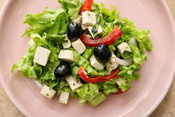 Plate with fresh Greek salad on color background, closeup